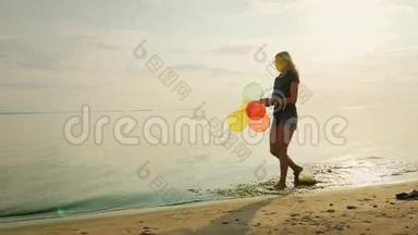 无忧无虑的年轻女子在美丽的天空中沿着海滩散步，手里<strong>拿</strong>着<strong>气球</strong>